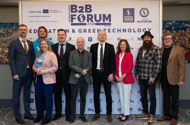 Yhteiskuvassa yhdeksän henkilöä seisomassa vierekkäin.