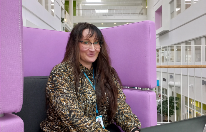 Minttu Porri istumassa violetilla sohvalla.