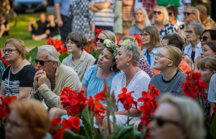 Kuvassa ihmisiä istumassa katseet käännettynä eteenpäin.