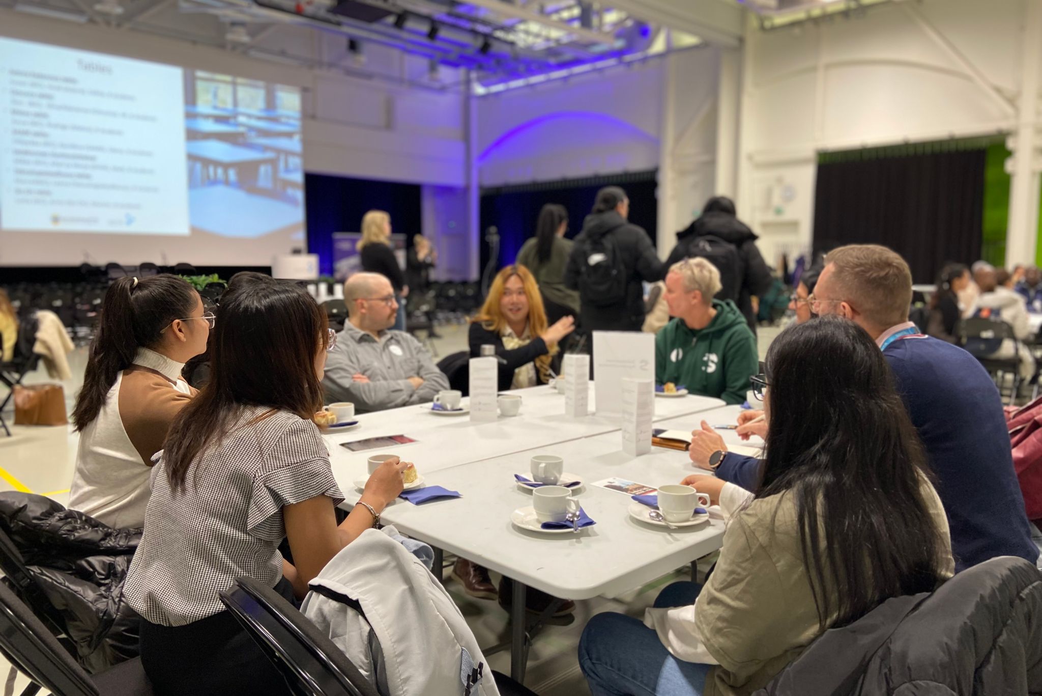 Ihmisiä pöydän ääressä keskustelemassa.