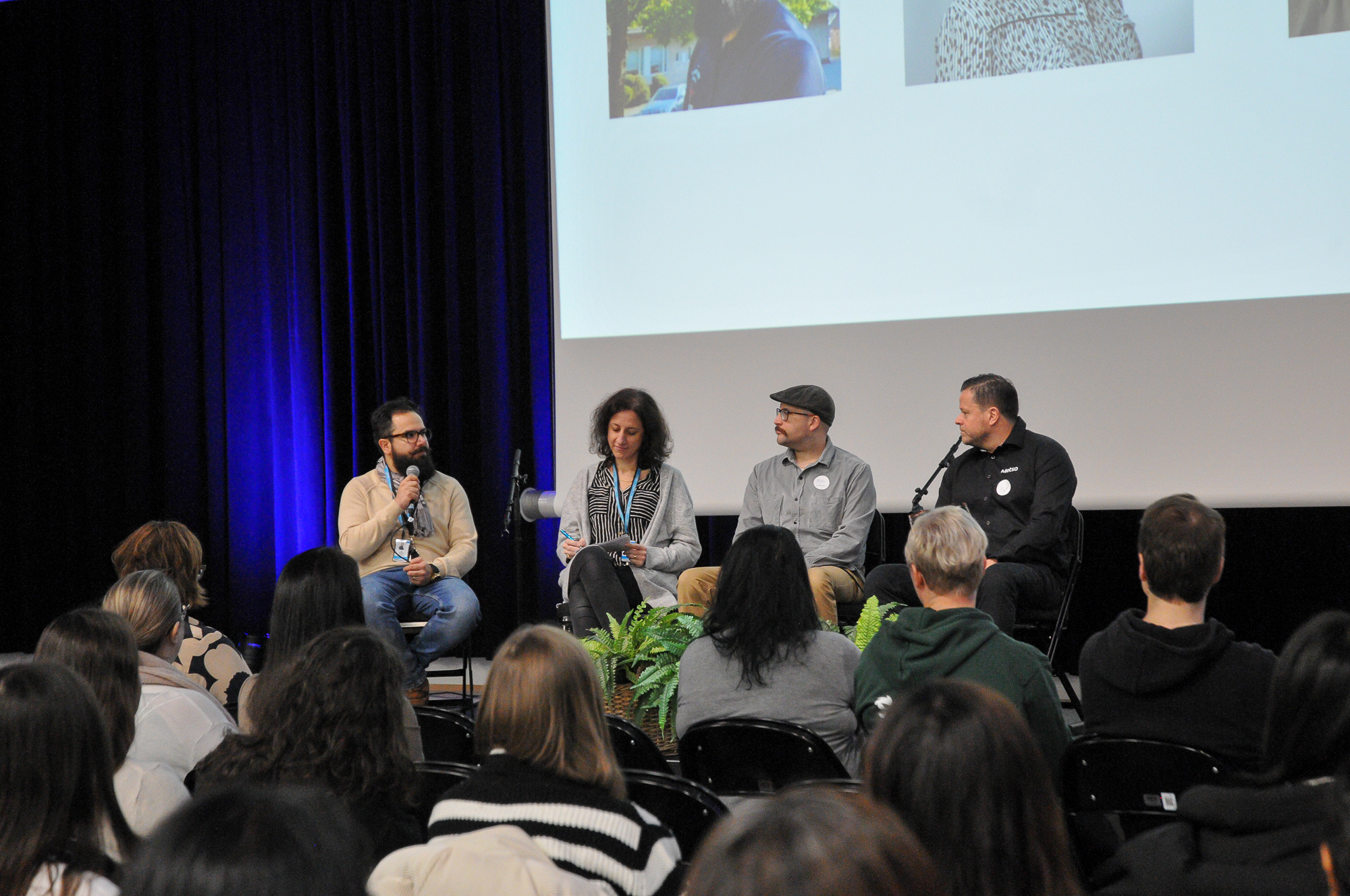 Neljä henkilöä lavalla panelisteina. 