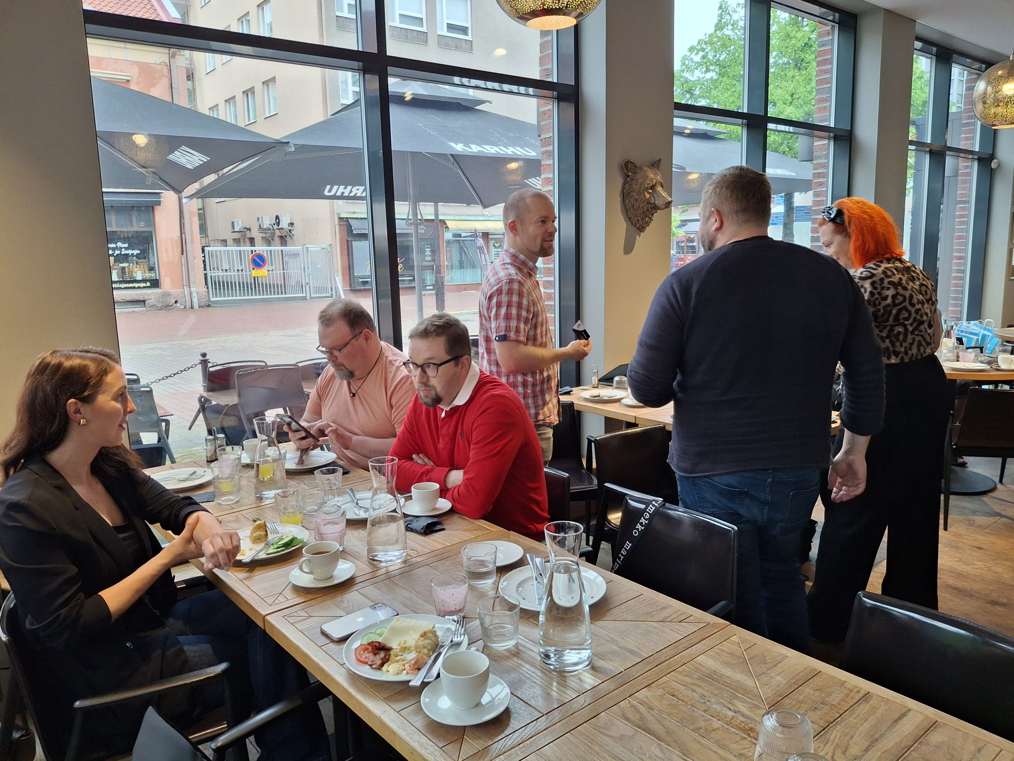 Ihmisiä keskustelemassa ryhmässä brunssitilaisuuden jälkeen.