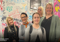 Ryhmä ihmisiä seisoo yhdessä värikkään graffitiseinän edessä. Tausta on täynnä eri väreillä tehtyjä tageja, piirroksia ja tekstejä. Vasemmassa alakulmassa näkyy Euroopan unionin osarahoittamaa -merkintä ja sen vieressä EU-lippu.