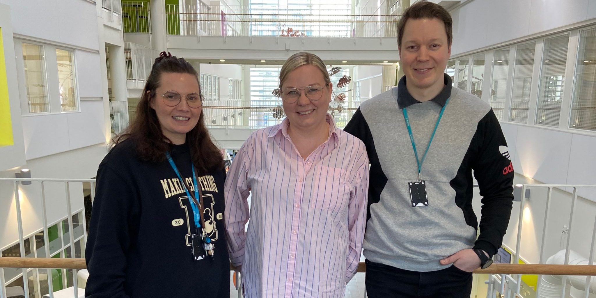 Lotta-Emilia, Paula, and Ollipekka are posing in the SAMK lobby.