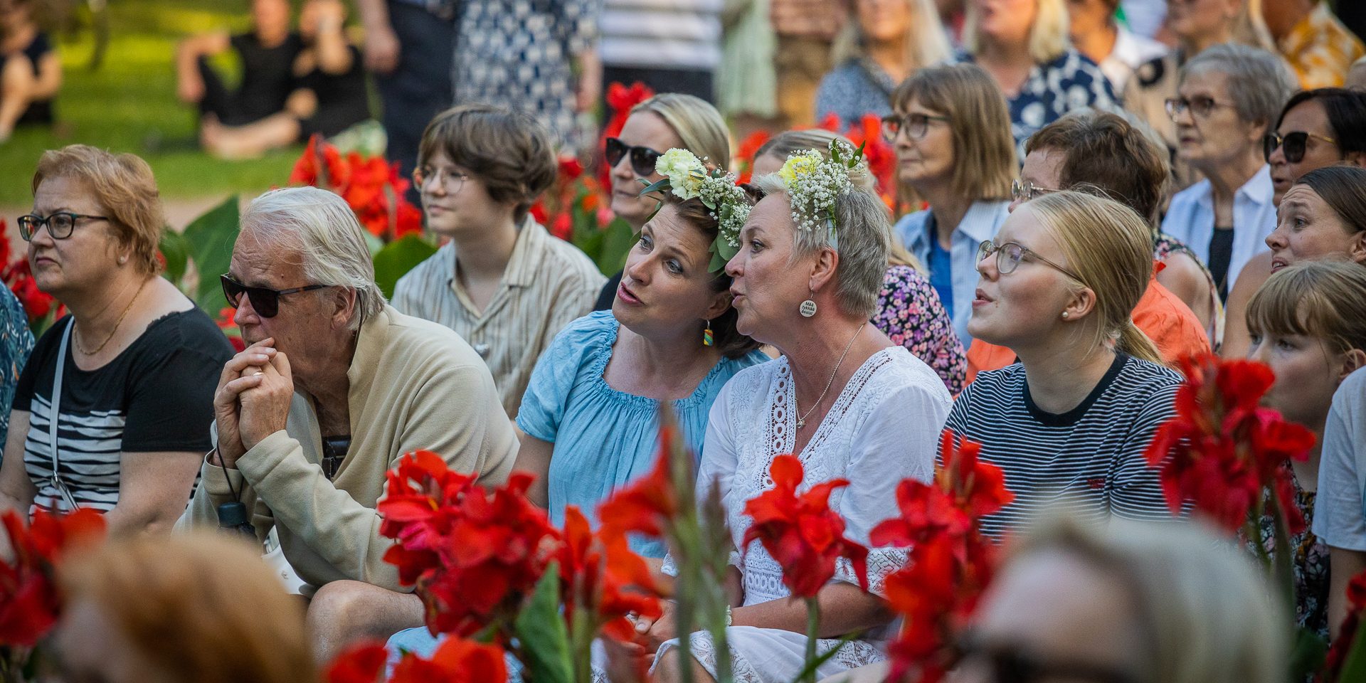 Kuvassa ihmisiä istumassa katseet käännettynä eteenpäin.