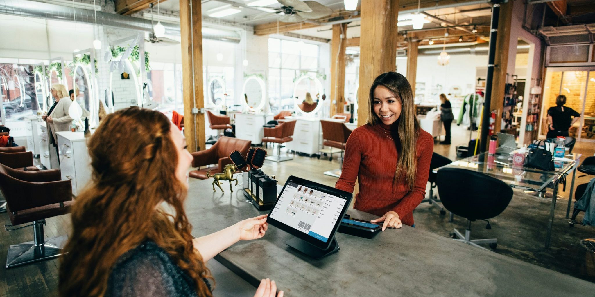 Myyjä ja asiakas kassatilanteessa.